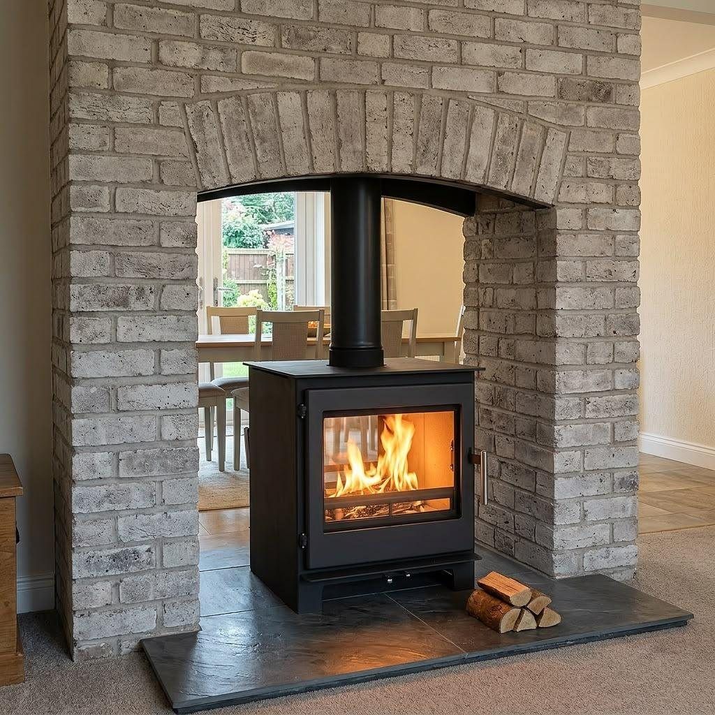 Double sided wood burning stove in an open brick chimney breast between two rooms