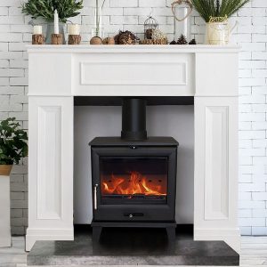Cedar 5 wood burning stove in a white fire surround with mantel shelf